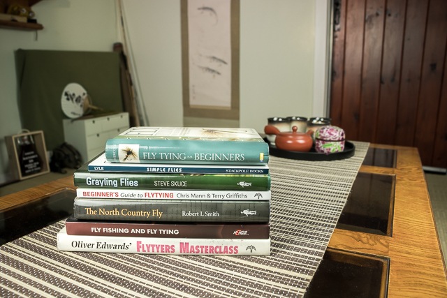 Fly Tying Books Piled on Table