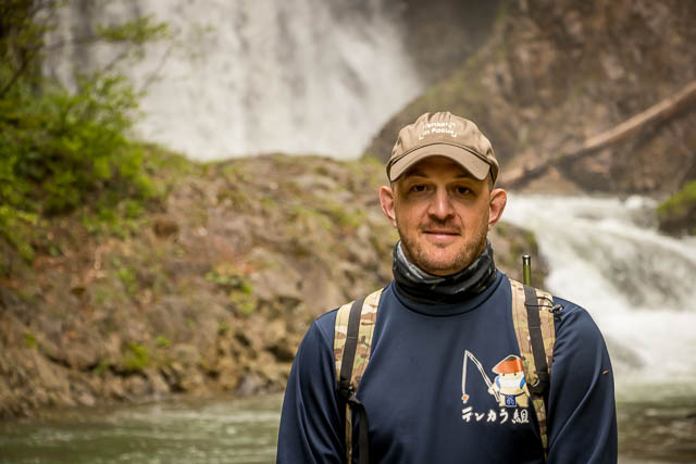 Isaac in front of a large waterfall