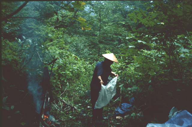 Sebata san tends to camp duties while his trademark fire reaches perfection